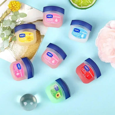 Hand holding trio from Plant‑Based Hydrating Lip Set against sunset beach scene, promoting travel‑friendly, nourishing, vegan lip‑care essentials.
