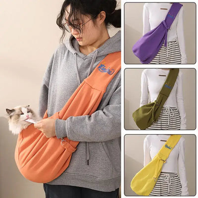 Woman using a portable cat carrier bag in orange, showcasing various colors for outdoor travel with pets.